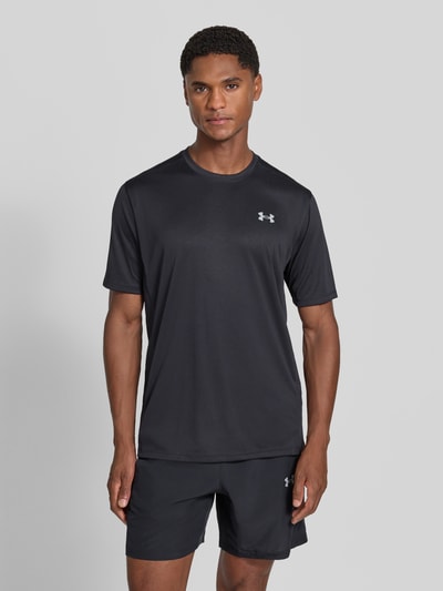 Männermodel trägt Regular Fit Sport-T-Shirt mit Label-Print von Under Armour in Schwarz mit glatter Textur, Ganzkörperansicht von vorne. Herren Sport-T-Shirt von Under Armour.