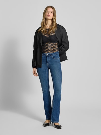 Frauenmodel trägt Flared Fit Jeans im 5-Pocket-Design von Review in mittelblauem Baumwoll-Mix, Ganzkörperansicht von vorne.