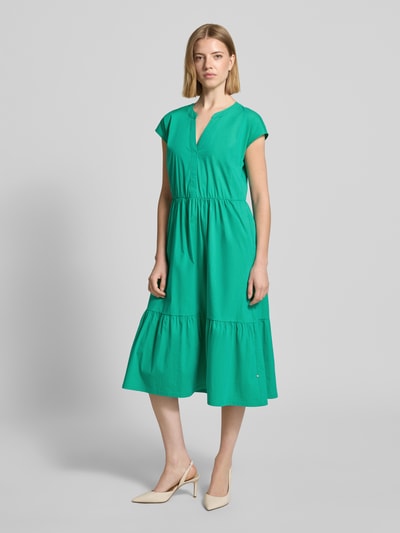 Frauenmodel trägt Knielanges Kleid im Stufen-Look mit V-Ausschnitt von ROBE LÉGÈRE in Grün, Baumwoll-Mix mit Stretch-Anteil, A-Linie, Kappärmel, glatte Textur, Stufen-Design, Knielänge, Ganzkörperansicht von vorne.