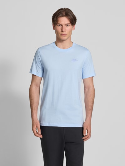 Männermodel trägt T-Shirt mit Label-Stitching von Nike, Hellblau, Reine Baumwolle, Regular-Fit, Rundhalsausschnitt, Rückenlänge 73 cm, Ganzkörperansicht von vorne.
