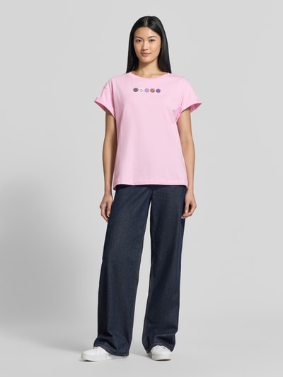 Frauenmodel trägt Relaxed Fit T-Shirt aus reiner Baumwolle von Rich & Royal in Rosa mit Ziersteinen, fixierte Ärmelumschläge, Ganzkörperansicht von vorne.