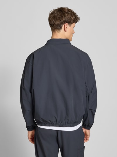 Männermodel trägt Regular Fit Hemdjacke mit Logo Modell 'HALO MOVE' von HALO in Dunkelblau mit Umlegekragen und Reißverschluss, Rückenlänge 66 cm, Ärmellänge 61 cm, Ganzkörperansicht Rückansicht.