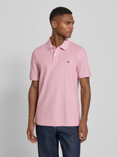 Männermodel trägt Regular Fit Poloshirt mit Logo-Stitching von Fynch-Hatton in Hellrosa, Baumwolle, Polokragen, Ganzkörperansicht von vorne.