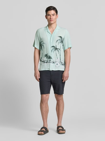 Męski model nosi Regular Fit Freizeithemd aus Viskose Modell 'RAYER_M' od BOSS Orange, jasny wzór palm, krój regular fit, koszula z krótkim rękawem, materiał wiskozowy, przód na całej długości, całkowity widok z przodu.