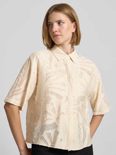 Frauenmodel trägt Regular Fit Bluse aus Viskose-Mix Modell 'Zlowera' von someday, cremefarben, Allover-Look, verdeckte Knopfleiste, Nahaufnahme Oberkörper.