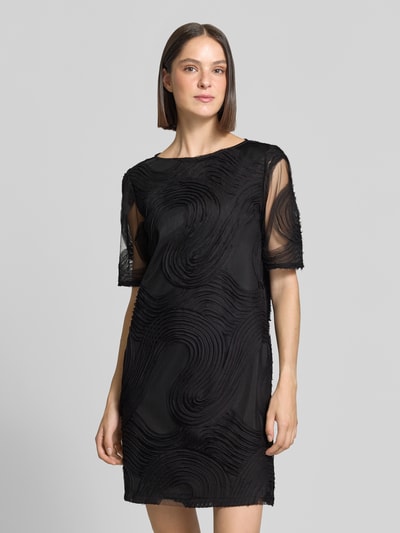Vrouwenmodel draagt zwart Relaxed Fit vrijetijdsjurk met structuurpatroon van s.Oliver BLACK LABEL, geheelopname van voren.