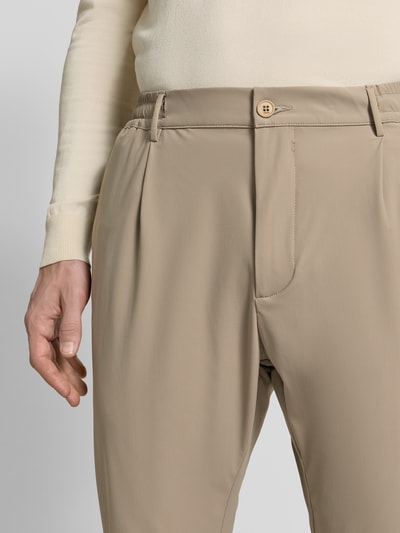 Männermodel trägt Slim Fit Hose mit Paspeltaschen am Gesäß von CRUNA in Beige, Material-Mix mit Stretch-Anteil, Eingrifftaschen, Nahaufnahme Oberkörper.