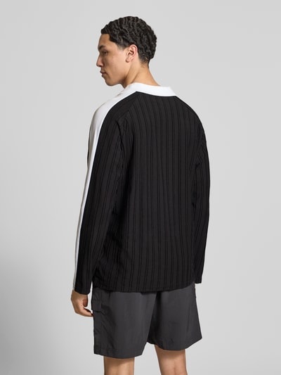 Männermodel trägt Relaxed Fit Polo-Longsleeve mit Label-Stitching von PUMA PERFORMANCE, schwarz-weiß, Längsstreifen, Rückenansicht, Ganzkörperansicht Rückansicht.