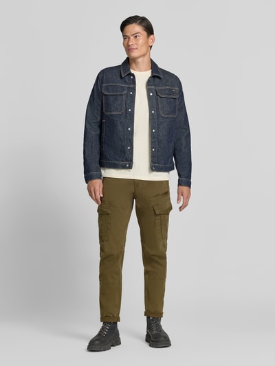 Männermodel trägt Slim Fit broek uit katoenmix in cargolook van PME Legend in olijfgroen met cargozakken, heren broek, ganzkörperansicht von vorne. Bandwijdte maat 32/32: 44 cm, binnenbeenlengte maat 32/32: 80 cm, knoop- en ritssluiting.
