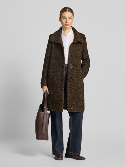 Vrouwenmodel draagt lange wollen jas van scheerwolmix Model 'PAMELA' van Milo Coats, bruin met steekzakken, recht, opstaande kraag, doorlopende knoopsluiting, Steekzakken, ruglengte maat 36: 101 cm, schouderbreedte 38 cm, borstwijdte 50 cm, mouwlengte 66 cm, geheel vooraanzicht.