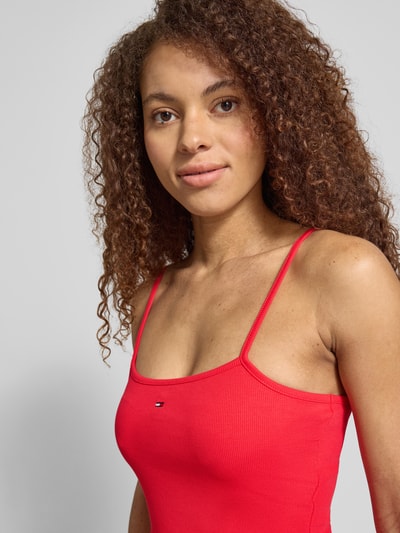Kobiece modelka nosi tailliertes Freizeitkleid aus reiner Baumwolle od Tommy Jeans, efekt: jednolity kolor, taliowany krój, mini, dekolt w łódkę, wyhaftowane logo, cienkie ramiączka, prosty dół, wpuszczane kieszenie, bawełna; zbliżenie na górną część ciała.