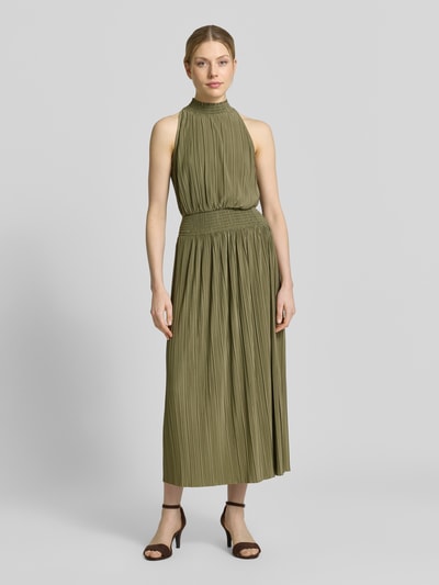 Frauenmodel trägt Plisseekleid mit Smok-Details Modell 'UMA' von Samsøe Samsøe in Olive, taillierter Schnitt, Midikleid, Ganzkörperansicht von vorne.