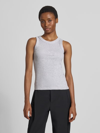 Frauenmodel trägt Tanktop in Ripp-Optik Modell 'OLINA' von DRYKORN aus reiner Baumwolle, Slim Fit, Rundhalsausschnitt, Ganzkörperansicht von vorne.
