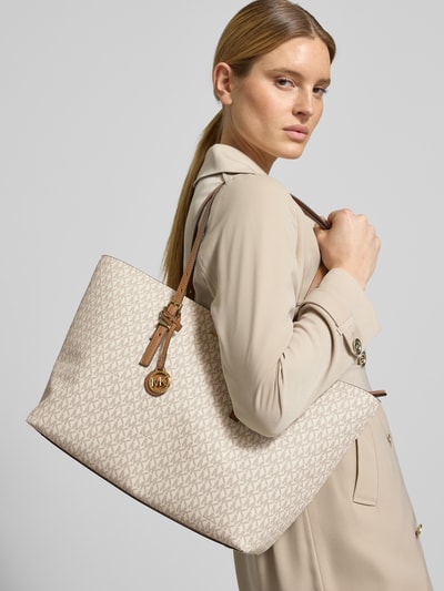 Frauenmodel trägt Shopper mit Label-Details Modell 'QUINN' von MICHAEL Michael Kors in Beige mit offenen Hauptfach, Nahaufnahme Oberkörper.