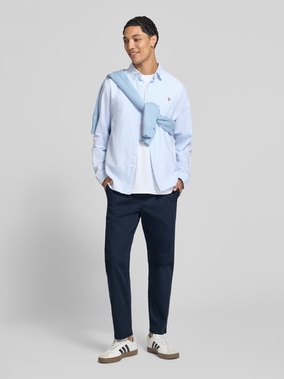 Männermodel trägt Straight Fit Hose aus katoenmix van REVIEW in navy met steekzakken en achterzakken, knoop- en ritssluiting, bandwijdte maat M 42 cm, binnenbeenlengte maat M 69 cm, geheel vooraanzicht.