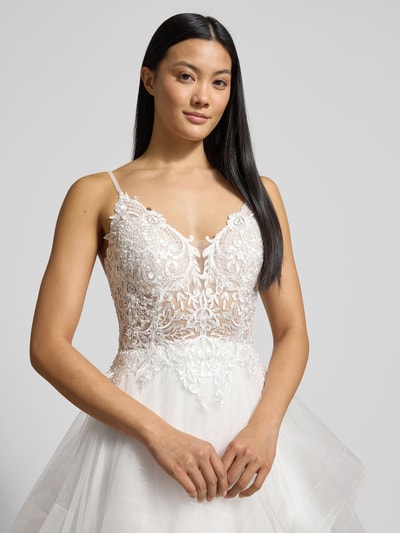Modelka kobieca nosi Brautkleid mit Details aus Spitze od LUXUAR FASHION, biała koronka, stonowane kolory, zbliżenie górnej części ciała, materiał trwały, fason taliowany, warstwowy dół, delikatna tekstura, dekolt w szpic. Nahaufnahme Oberkörper.