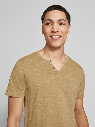 Mężczyznamodel nosi T-Shirt aus Baumwolle Modell 'SPLIT' von Jack & Jones, bawełna, prosty krój, V-dekolt, zapięcie na guziki, długość tyłu 67 cm w rozmiarze M, beżowy kolor, melanżowa faktura, półzbliżenie klatki piersiowej