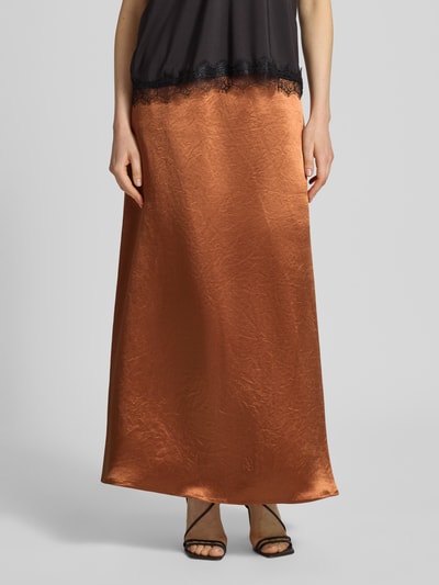 Kobiece model prezentuje długą spódnicę z satyny z elastycznym pasem model 'TUONO' od MM by Max Mara, linia a, miedziany kolor, gładka satynowa powierzchnia, szerokość w rozmiarze 36: 37 cm, całkowita długość w rozmiarze 36: 106 cm, zdjęcie całej sylwetki od przodu.