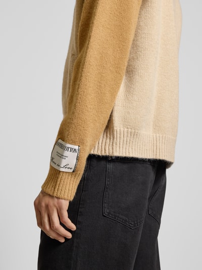 Männermodel trägt Strickjacke mit Reißverschluss von ANOTHER COTTON LAB, Material-Mix, Regular-Fit, gerippte Abschlüsse, Detailaufnahme.