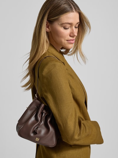 Männermodel trägt brązową Tasche mit Label-Applikation Modell NEEKO von HUGO w skórzanej optyce, tunelzug, pasek na ramię, z ekoskóry, nahaufnahme górnej części ciała