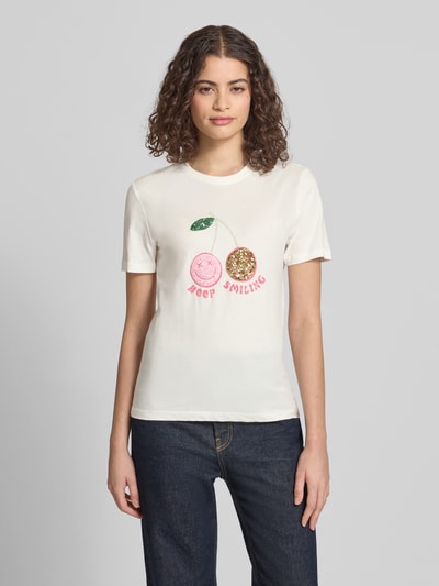 Frauenmodel trägt Regular Fit T-Shirt aus reiner Baumwolle Modell 'KITA' von Only, Optik: Unifarben, Motiv-Print, Paillettenbesatz, Rundhals, Kurzarm, Materialverarbeitung: Jersey, Ganzkörperansicht von vorne.