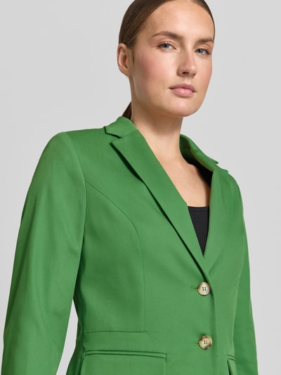 Frauenmodel trägt Slim Fit Blazer mit 3/4-Arm von More & More, kräftiges Grün, Reverskragen, Pattentaschen, Viskose-Baumwoll-Mix, Nahaufnahme Oberkörper.