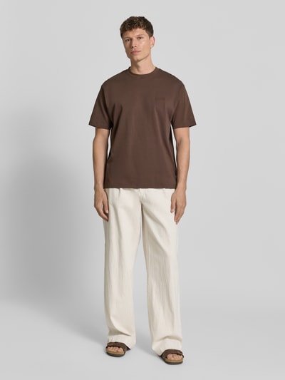 Männermodel trägt Hose mit Eingrifftaschen und elastischem Bund von bugatti, cremefarben, lockerer Schnitt, Baumwoll-Leinen-Mix, Ganzkörperansicht von vorne.