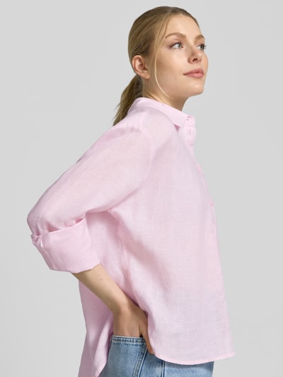 Frauenmodel trägt Regular Fit Hemdbluse aus reinen Leinen von Christian Berg Woman Selection in zartem Rosa mit Hemdblusenkragen und Knopfleiste, langärmliges Design, reine Leinenstruktur mit leichter Transparenz, Nahaufnahme Oberkörper seitlich.