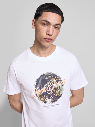 Männermodel trägt T-shirt met print, model 'HONOLULU' van Jack & Jones, puur katoen, regular fit, witte kleur, ronde hals, nahaufnahme bovenlichaam.