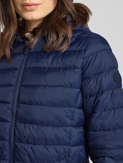 Vrouwenmodel draagt Steppjacke mit Kapuze Modell 'THELMA' van CARS JEANS in regular fit, blauw, horizontale stiksels, detailopname bovenlichaam.