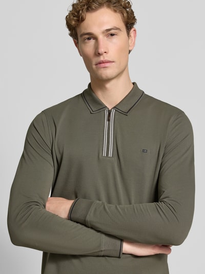 Männermodel trägt Slim Fit Poloshirt mit Reißverschluss von Christian Berg Men in Olivgrün, reine Baumwolle, Longsleeve, Nahaufnahme Oberkörper.