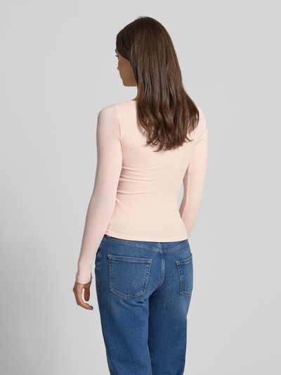 Frauenmodel trägt Longsleeve mit V-Ausschnitt und Spitze von Gina Tricot aus Baumwoll-Mix mit Modal-Anteil in Slim-Fit, Feinripp, Rückenlänge bei Größe S 53 cm, hellrosa Farbton, Ganzkörperansicht Rückansicht.