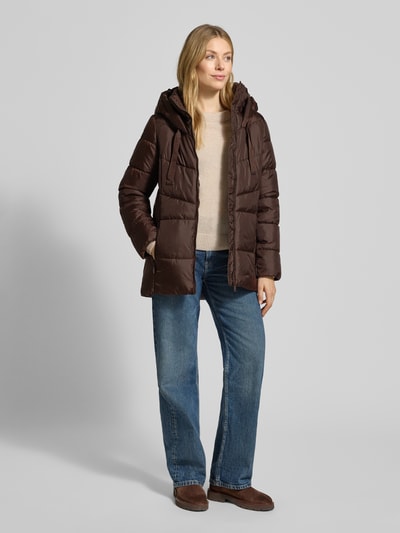 Frauenmodel trägt Regular Fit Steppjacke mit Kapuze von s.Oliver CASUAL, braun, unifarben, elastische Abschlüsse, Ganzkörperansicht von vorne.