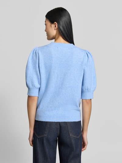 Frauenmodel trägt Regular Fit Pullover mit Puffärmeln von VERO MODA in Hellblau, grobe Strickstruktur, kombiniert mit dunkler Jeans, Ganzkörperansicht Rückansicht.