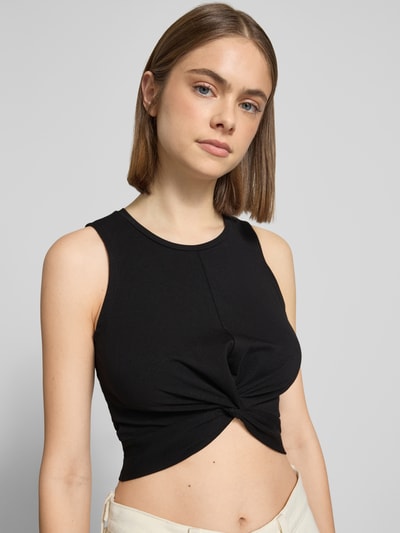 Vrouwenmodel draagt zwart Crop Top met Knotendetail model 'TWIGGI' van Noisy May, katoenmix met stretch, ronde hals, kort, Nahaufnahme Oberkörper.