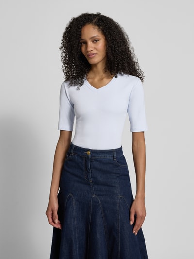 Kobiece model prezentuje T-shirt mit V-Ausschnitt od Christian Berg Woman, mieszanka bawełny i elastanu, krój regular fit, dekolt w serek, rękaw o dł. 1/2, długość tyłu w rozmiarze S: 55 cm, widok całej sylwetki z przodu