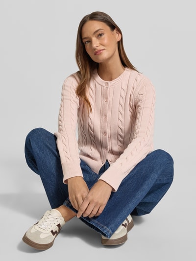 Kobiece model prezentuje Kardigan rozpinany z ściegiem warkoczowym i okrągłym dekoltem od JAKE*S STUDIO WOMAN, bawełna, krój slim fit, listwa guzikowa, długość tyłu w rozmiarze S: 52 cm, długość rękawa w rozmiarze S: 67 cm, ujęcie całego ciała z przodu.