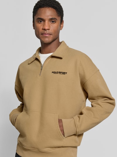Männermodel trägt regular fit schipperstrui van katoenmix 'Regular Fit Troyer aus Baumwoll-Mix' van Polo Ralph Lauren in beige, nahaufnahme oberkörper.