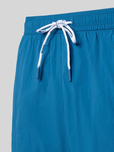 Produktfoto, Regular Fit Badeshorts mit Label Print Modell 'MOONEYE' von BOSS, Optik: Unifarben, Applikation: Label-Print, Bundabschluss: Elastisch mit Tunnelzug, seitliche Eingrifftaschen, strukturierte Oberfläche in Blau