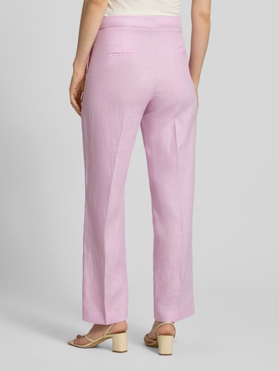 Frauenmodel trägt Straight Fit Leinenhose mit Bügelfalten Modell 'Boreli' von Mango in zartem Rosa, leichte Struktur, Rückansicht, Damen Leinen, Haken- und Reißverschluss, Bundweite 37 cm, Innenbeinlänge 77 cm, Größe 36, Ganzkörperansicht Rückansicht.