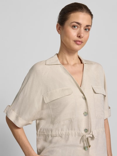 Modelka kobieca ma na sobie Hemdbluse aus Leinen-Viskose-Mix von Christian Berg Woman Selection, jasnobeżowa, guzikowa, półrękaw, kieszenie, kołnierz, tunel w talii, długość tyłu w rozmiarze 36: 56 cm, szerokość w rozmiarze 36: 55 cm, długość rękawa w rozmiarze 36: 28 cm, tekstura gładka, widok na górną część ciała z przodu
