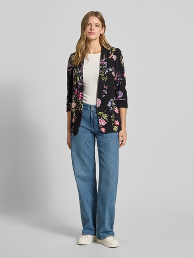 Kobiece modelka nosi Regular Fit Longblazer mit Allover-Muster Model 'BOSELLA' od Pieces, efekt: wzór na całej powierzchni, kołnierz z połami, poduszki na ramionach, rękaw o dł. 3/4 z marszczeniem, wykończenie materiału: tkana faktura. Ganzkörperansicht von vorne.