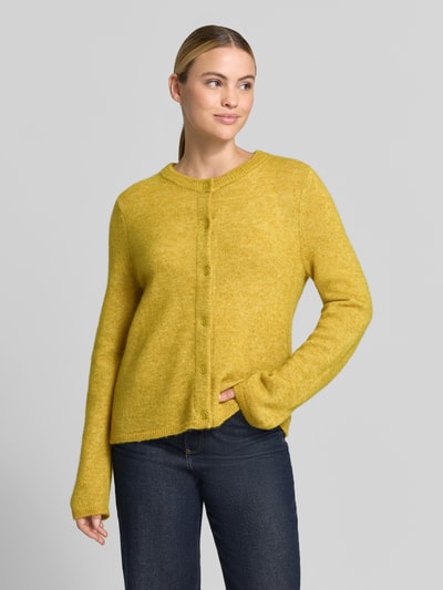 Kobiece model nosi żółty kardigan rozpinany Relaxed Fit z mieszanki wełny model 'LULU' od Selected, damski kardigan, zdjęcie całej sylwetki z przodu.