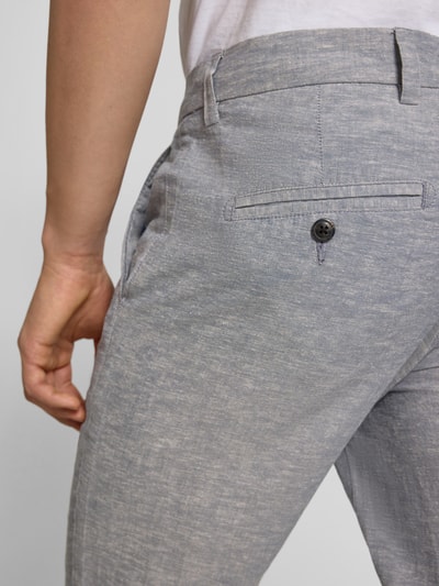 Männermodel trägt Tapered Fit Hose mit Eingrifftaschen Modell 'STACE' von Jack & Jones, grijs met katoenmix, detailopname heup, context: heren broek, tapered fit, steekzakken, taillewijdte 45 cm, binnenbeenlengte 77 cm bij maat 32/32.
