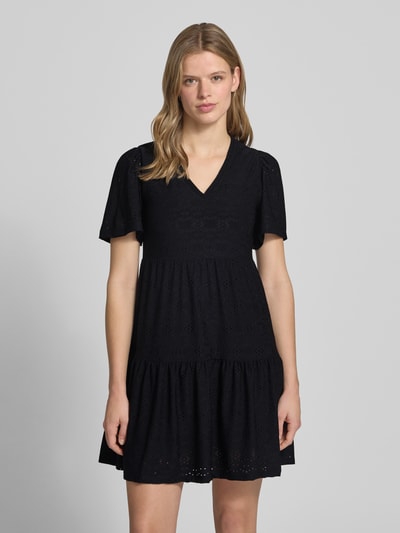 Kobiece modelka nosi Mini-Freizeitkleid mit Lochstickmuster Modell 'SMILLA LIFE' von Only, czarna, unikatowa faktura, krój regular fit, dekolt V, mini, krótkie rękawy, widok na całe ciało z przodu.