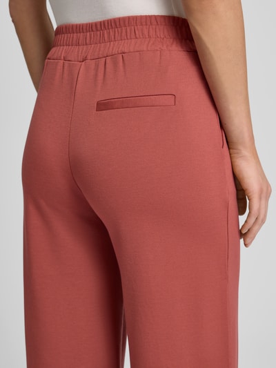 Frauenmodel trägt Wide Fit Stoffhose mit Viskose-Anteil Modell 'Kate' von ICHI in Altrosa, elastischer Bund, Gesäßtasche, Detailaufnahme Rückansicht.