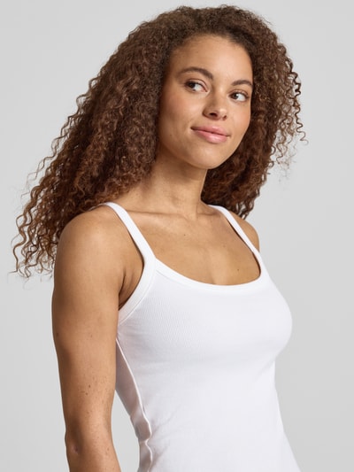 Frauenmodel trägt Slim Fit Tank Top aus Bio-Baumwoll-Mix Modell 'MAY' von Pieces, weiß, fein gerippte Struktur, Nahaufnahme Oberkörper.