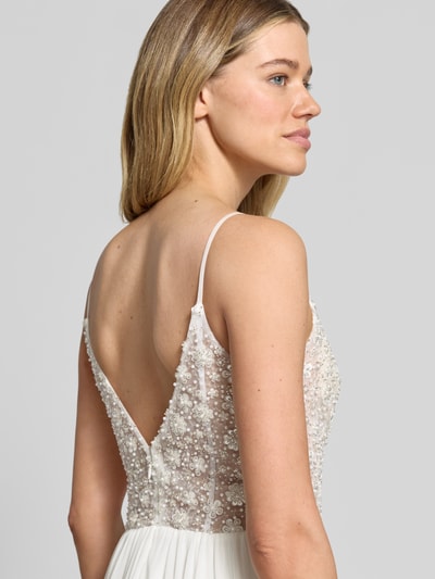 Frauenmodel trägt Brautkleid mit Ziersteinbesatz von Hey Kyla in Weiß, transparente Ziersteine, taillierte Passform, Spaghettiträger, Nahaufnahme Oberkörper Rückansicht.