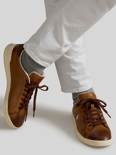 Männermodel trägt Low Top Sneaker aus echtem Leder von Polo Ralph Lauren in Braun mit Farbverlauf, Logo-Print, Velours-Detail, Ganzkörperansicht von vorne.
