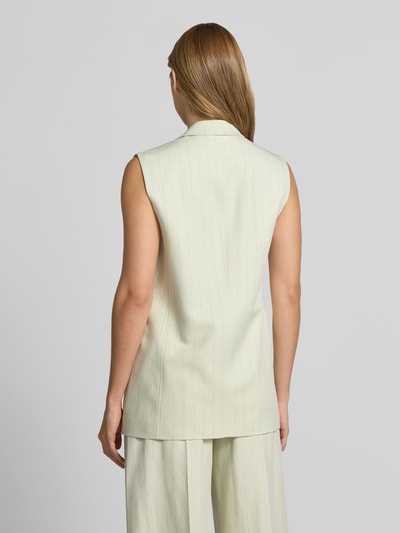 Frauenmodel trägt Regular Fit Anzugweste mit Leinen-Anteil Modell 'JAKILY' von BOSS Orange, Optik:Allover-Muster, Nadelstreifen-Muster, Reverskragen, V-Ausschnitt, 1-Knopf-Verschluss, Pattentaschen, Materialverarbeitung: Twill, Lyocell-Baumwoll-Leinen-Mix, helle Farbe, feine Streifen, glatte Textur, Ganzkörperansicht Rückansicht.